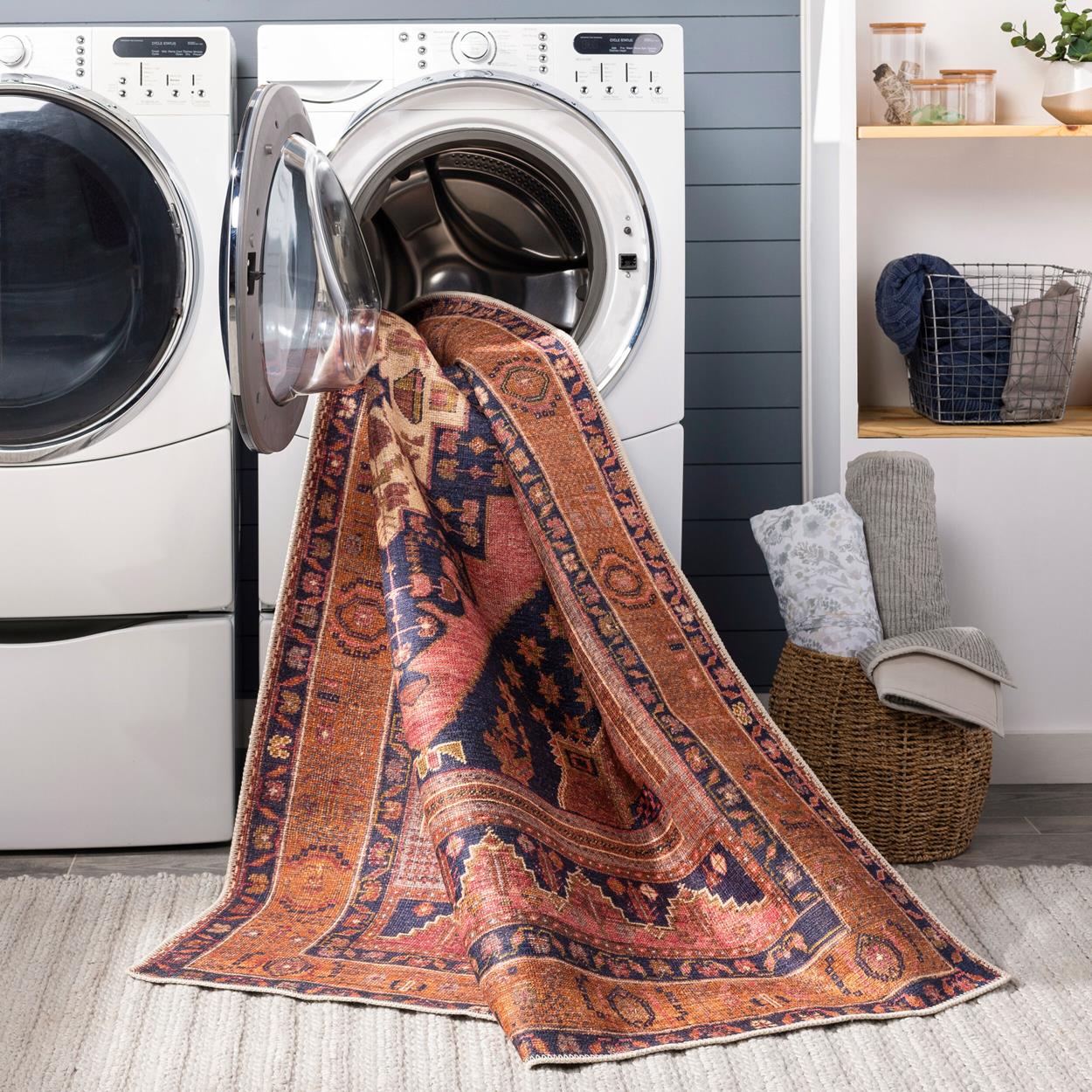 an antique style rug hanging out of a washing machine.