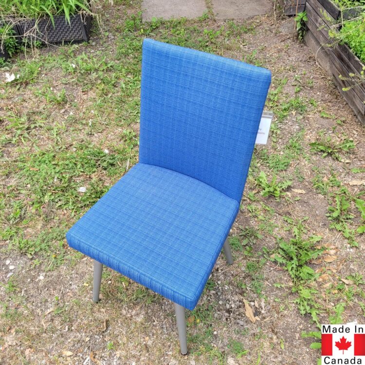 A medium blue dining chair, with tapered silver legs.
