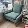 Mid century modern accent chair in muted green upholstery.