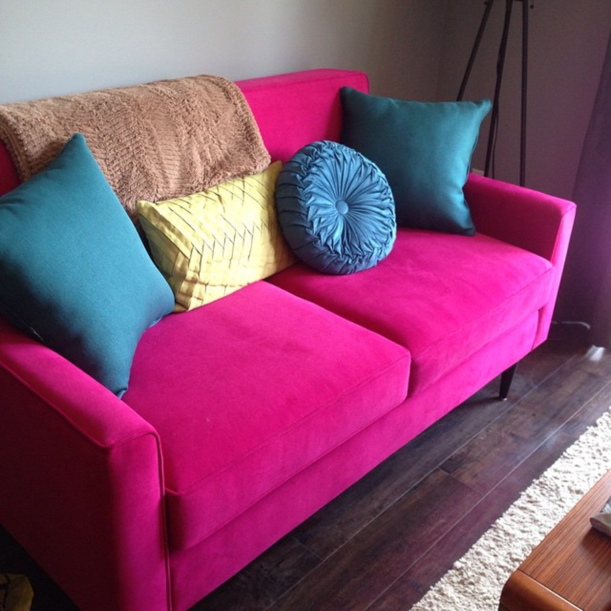 helsinki-loveseat-drummond-dahlia-2-1250sq Bright pink loveseat with blue throw pillows.