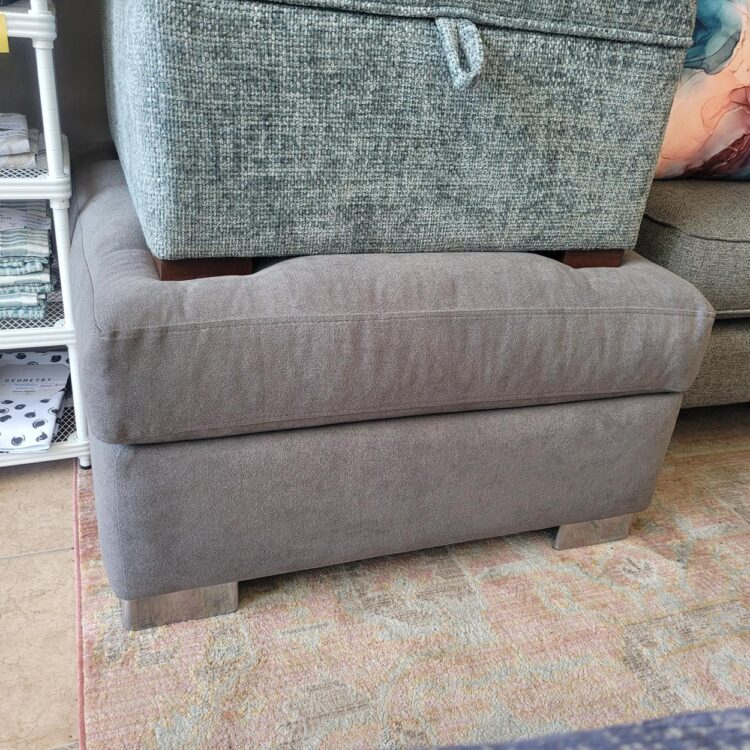Square grey ottoman with soft feather top.