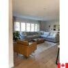 Light blue sectional sofa with a deep seat. In a sunny room with a tan coloured chair.