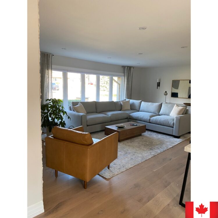 Light blue sectional sofa with a deep seat. In a sunny room with a tan coloured chair.