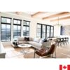 Large living room with light grey sectional sofa. Has slim boxy arms, and a silver metal leg.