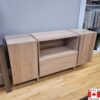 Light wood buffet with one door on each end. One large centre drawer with an open space above.